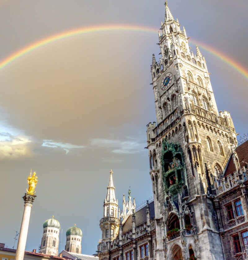 Blick auf das Neue Rathaus am Marienplatz in München mit Regenbogen am Himmel – Symbolbild für das neue Staytoo Studentenapartment-Haus in München