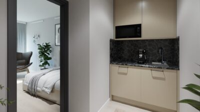 Kompakte Küchenzeile in einem Studentenapartment im Staytoo München mit Kochfeld, Spüle und Mikrowelle